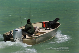 Picture of a man and his dog in a fishing boat.  Find more free pictures and wallpapers at www.FreePhotoCourse.com.  © 2011, FreePhotoCourse.com; all rights reserved.  