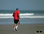 Picture of a man in a red shirt and blue ballcap, jogging on the beach. © 2011, FreePhotoCourse.com, all rights reserved.  Awesome beach pictures & wallpapers. Download free jpg, jpeg photos. 