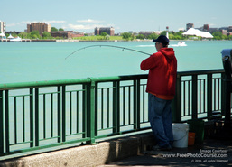 Picture of a man fishing at the railing along a river's edge.  Find more free pictures and wallpapers at www.FreePhotoCourse.com.  © 2011, FreePhotoCourse.com; all rights reserved.  