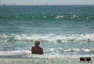 Picture of a man wearing a sun hat sitting on the seashore.© 2011, FreePhotoCourse.com, all rights reserved.  Awesome beach pictures & wallpapers. Download free jpg, jpeg photos.  