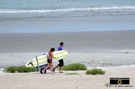 Picture of a young couple rolling their surfboard down the beach. © 2011, FreePhotoCourse.com, all rights reserved.  Awesome beach pictures & wallpapers. Download free jpg, jpeg photos. 