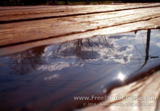 Sky Reflected in Puddle on Deck - Fine Art Photography Tips and Lessons - © 2010, Kevan Donais.  Visit www.FreePhotoCourse.com, all rights reserved 