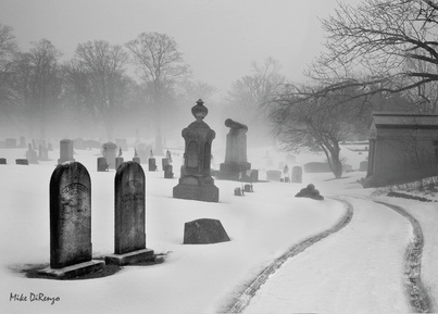 Picture of a winter graveyard scene.  Both haunting and serene.  Beautiful artistic photography, part of FreePhotoCourse.com's 2010-11 Winter Challenge Contributor's Gallery.  © 2011, all rights reserved.  Photo Credit: Mike DiRenzo.   