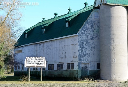 Picture of a farm barn with a traditional religious Christian sign in the foreground.  Part of a photo composition tutorial by FreePhotoCourse.com; © 2012, all rights reserved.