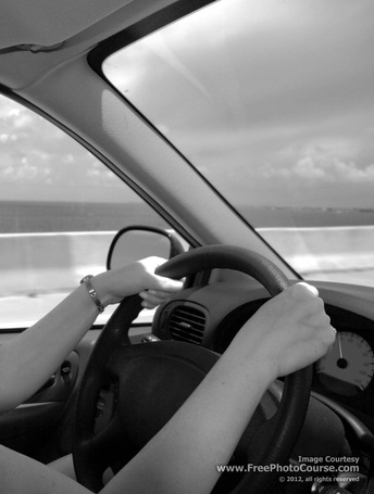 Picture of a woman driving a car - part of a photography article on how to get clearer pictures.  Photography Tips at FreePhotoCourse.com.  Photo Credit: Stephen Kristof,© 2012, all rights reserved.