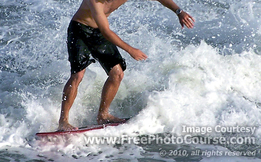 Picture of a surfer on a surfboard, riding a wave. Enjoy more free pictures from http://www.FreePhotoCourse.com.