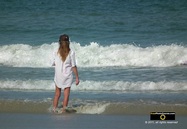 Picture of an attractive woman wearing a man's shirt, standing at the water's edge on a beach. © 2011, FreePhotoCourse.com, all rights reserved.  Awesome beach pictures & wallpapers. Download free jpg, jpeg photos.  