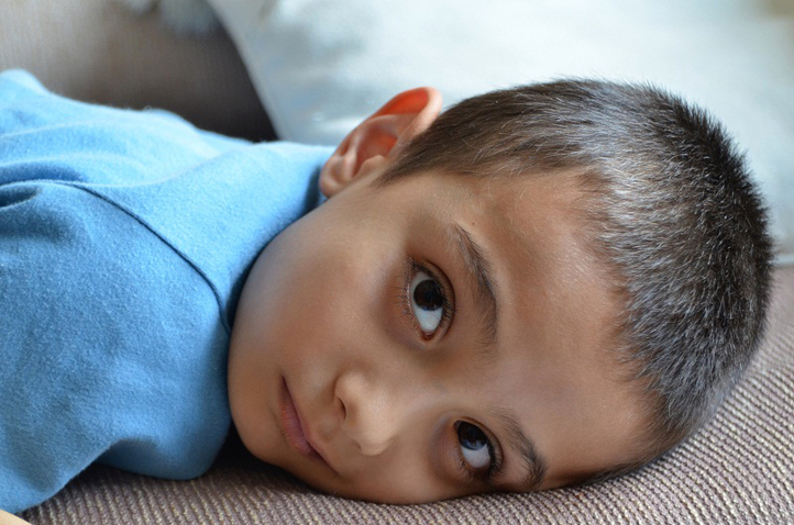 Picture of an inquisitive, wide-eyed young boy resting on a sofa.  A photo by Brice Denize, featured in FreePhotoCourse.com's Contributor's Gallery for the October 2012 selections.  (c) 2012, all rights reserved.