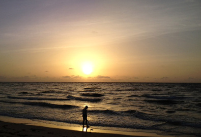 Picture of a man using a metal detector on Boynton Beach, Florida.  Featured in the September 2012 Contributor's Gallery at FreePhotoCourse.com.  Photo Credit: Maritza Baez, all rights reserved.