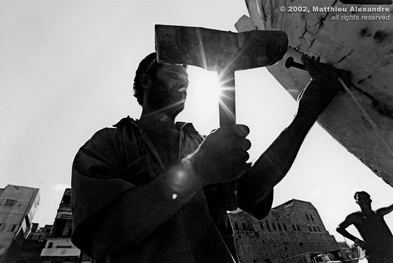 Picture of a Lebanese worker in Tyr, repairing a fishing boat using a wooden hammer.  © 2002, Matthieu Alexandre; part of FreePhotoCourse.com's “Photographer Profiles” series; DO NOT COPY – IP Address recorded - all rights reserved.