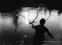 Picture of a man net-fishing in a river in Nepal.  © 1998, Matthieu Alexandre; part of FreePhotoCourse.com's “Photographer Profiles” series; DO NOT COPY – IP Address recorded - all rights reserved.