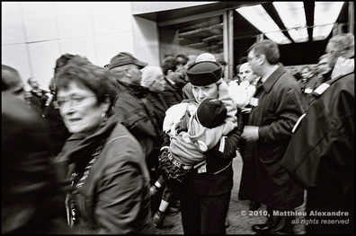 Picture of a French airline stewardess at Orly Airport, south of Paris, carrying an Iraqi child who is part of a group of wounded refugees.  © 2010, Matthieu Alexandre; part of FreePhotoCourse.com's “Photographer Profiles” series; DO NOT COPY – IP Address recorded - all rights reserved.